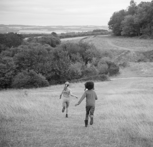 Deux enfants courant dans un champ à la campagne